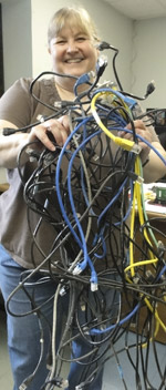 Photo of smiling client holding out a jumple of discarded patch cords.
